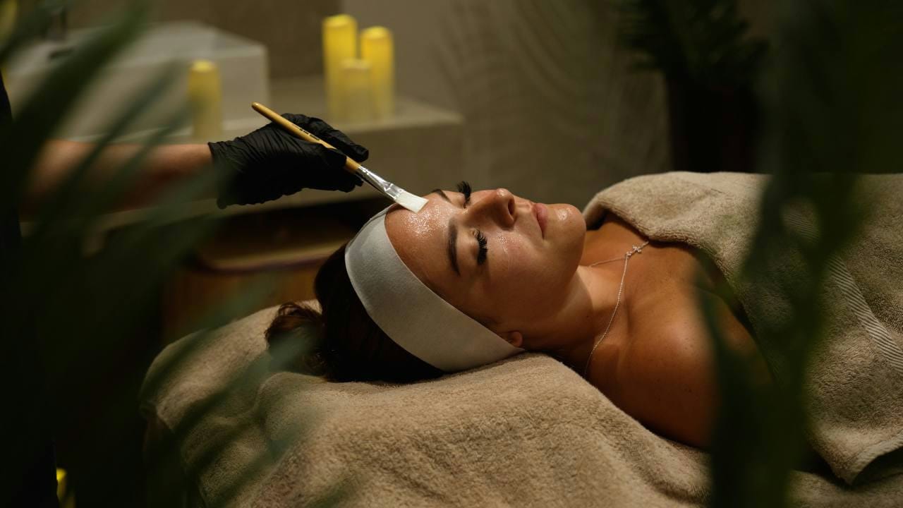 A jelly mask being applied to a guest's face