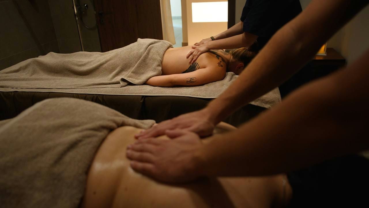 A therapist working on a guest's shoulders