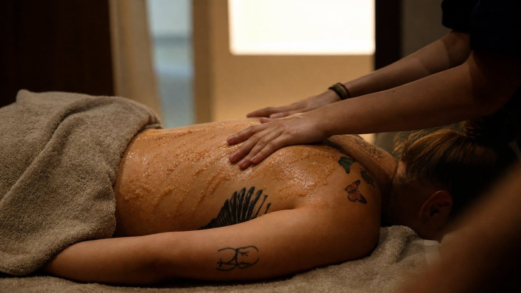 A therapist working salt scrub into a guest's back